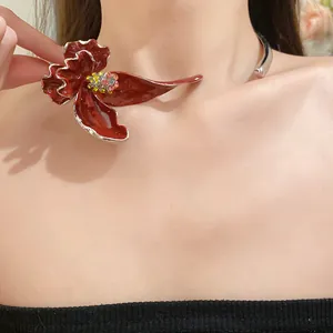 Vue détaillée d'un collier ras du cou en fleur d'émail rouge avec des strass brillants