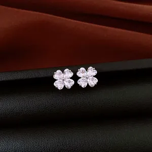 Detailed macro shot of elegant silver stud earrings with heart shaped zircon flower design