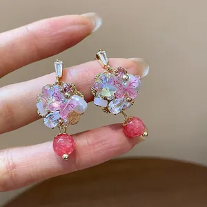 Close-up of 14K gold plated flower earrings featuring pink stone beads and crystals