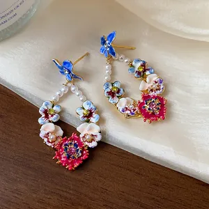 Exquisite floral hoop earrings featuring colorful enamel flowers, pearls and pink crystals.