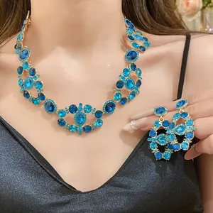 Detailed view of luxury blue rhinestone necklace and earring set in vintage gold finish