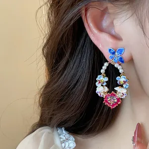 Close-up detail of 14K gold plated floral hoop earrings featuring colorful petals and pearls