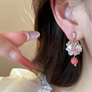 Detailed view of an elegant 14K gold plated floral stud earring with pink crystals