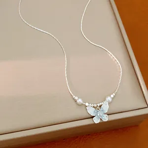 Gros plan d'un collier pendentif papillon argenté élégant avec perles et perles