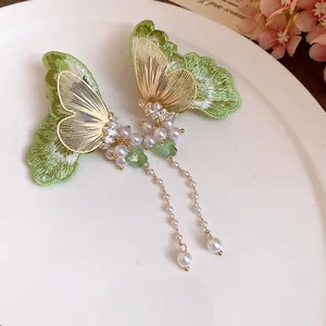 Detailed view of embroidered butterfly earrings with elegant pearl tassels and CZ accents.
