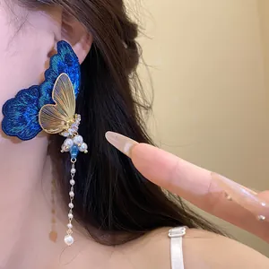Close-up of elegant embroidery butterfly tassel earrings with pearls and zircons