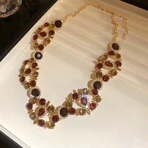 Detail view of a vintage court style necklace with brown and red gemstones