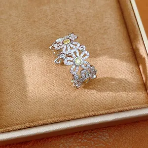 Detailed macro view of a zircon-encrusted floral open ring with yellow stone accents