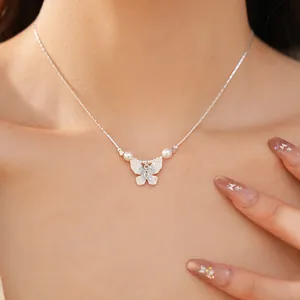Vue détaillée d'un élégant collier papillon et perles sur une chaîne ras du cou