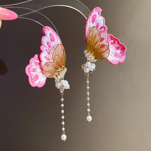 Close-up of pink embroidery butterfly earrings with elegant pearl tassels and zircons
