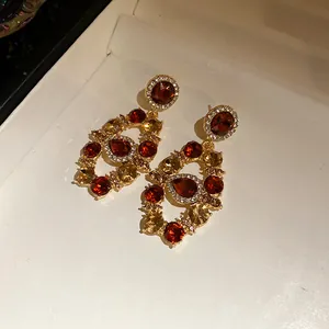 Exquisite macro detail of vintage court style dangle earrings with red and amber crystals