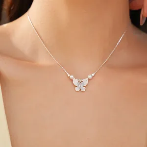 Gros plan détaillé d'un collier papillon en argent délicat avec des perles blanches