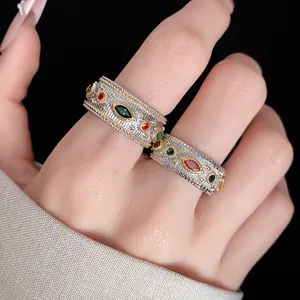 Primo piano di anelli vintage con zirconi colorati sulle dita della mano.