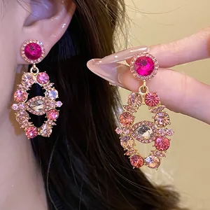Detailed view of luxury vintage court style gold earrings encrusted with pink rhinestones
