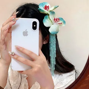 Elegant cloth flower hair clip featuring mint green glass bead tassels, shown on model