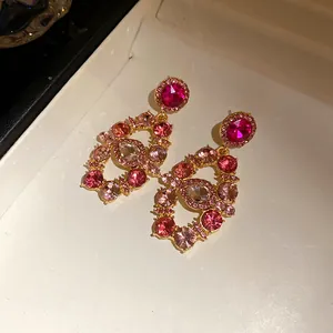 Detailed view of vintage palace style earrings with pink rhinestones in gold-tone finish