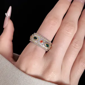 Dettaglio ravvicinato di un anello aperto vintage con zirconi verdi e arancioni