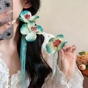 Close-up of elegant floral fabric hair clip with light blue glass bead long tassels on model