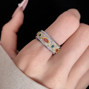 Primo piano di un anello vintage in stile corte con zirconi colorati su fascia d'argento.