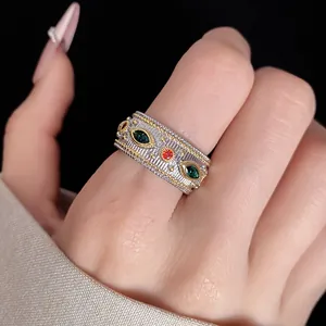 Dettaglio di un anello testurizzato in stile vintage con zirconi verdi e rossi