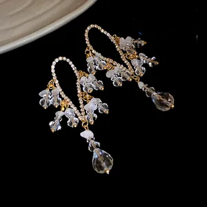 Eleganti orecchini pendenti a nappa dorata con cristalli sfaccettati e strass lucidi