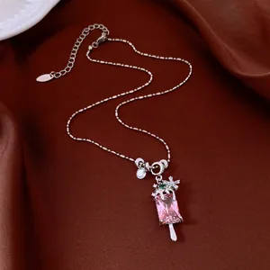 Vue détaillée d'un collier pendentif esquimau argenté avec des pierres roses brillantes.