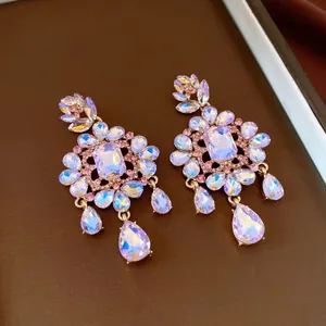 Close-up of elegant gold-toned flower drop earrings with iridescent crystals