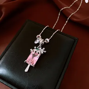 Gros plan d'un collier popsicle en zircon rose avec accents floraux sur boîte noire.