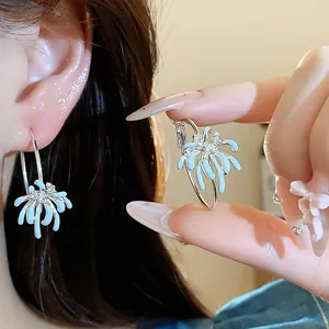 Detailed macro view of light blue enamel flower hoop earrings with sparkling zircon centers.