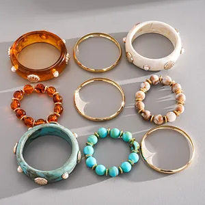 Set of 9 Bohemian style retro resin and beaded bracelets with gold bangles and shell details