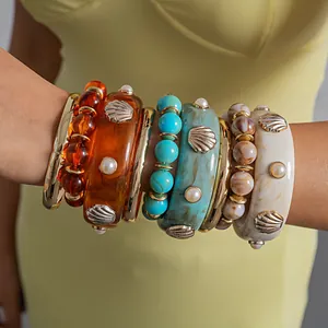 Close-up of colorful stacked resin shell and beaded bracelet set in bohemian style
