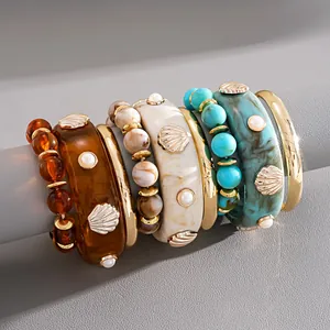 Close-up of bohemian style resin shell bangles and beaded bracelets jewelry set for women