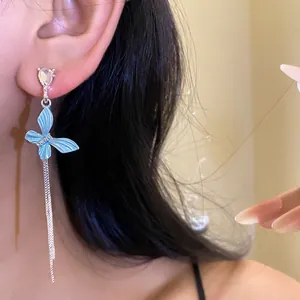 Eleganti orecchini a farfalla in argento con smalto blu e strass brillanti su modella