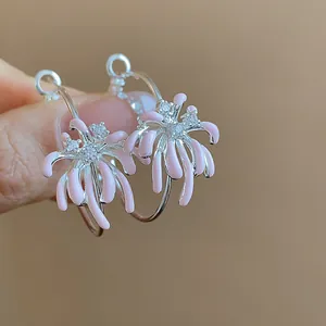 Close-up of elegant silver hoop earrings with pink enamel flower clusters and zircons.