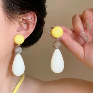 Fashionable dopamine style resin teardrop earrings with yellow and grey bead accents on model