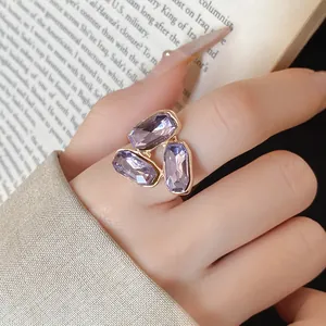 Elegante anello aperto dorato con tre cristalli viola ovali per il dito indice.
