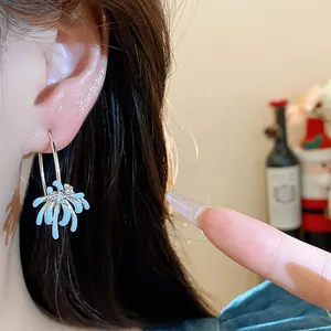 Close-up of delicate light blue flower drip oil hoop earring with zircon accents