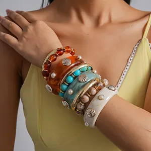 Bohemian resin shell beaded bracelets set worn by a female model in yellow dress