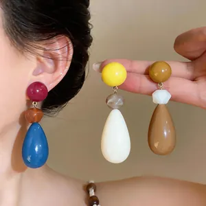 Detailed shot of vibrant colorful resin teardrop earrings with silver needle studs