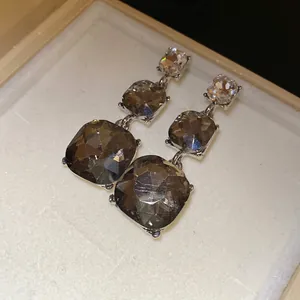 Detailed view of vintage-style tiered smoky crystal drop earrings in a gift box