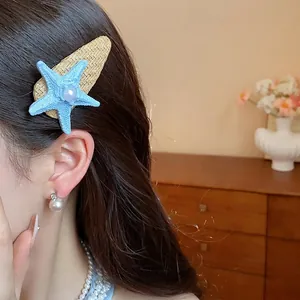 Bohemian blue starfish hair clip with pearl detail for stylish seaside vacation wear.