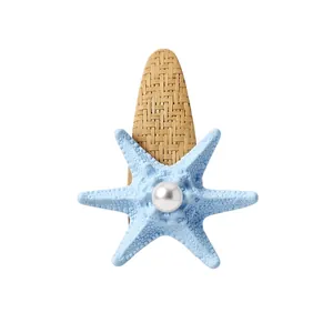 Bohemian style blue starfish hair clip with a white pearl and straw woven texture base