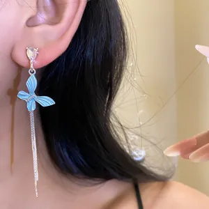 Dettaglio ravvicinato di orecchini a farfalla blu con strass brillanti e nappe