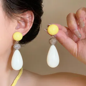Close-up of dopamine colorful resin teardrop earrings with silver needle shown on model