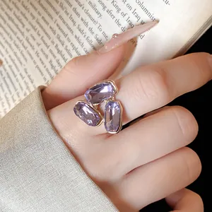 Primo piano di un elegante anello a grappolo di cristallo viola indossato sulla mano.
