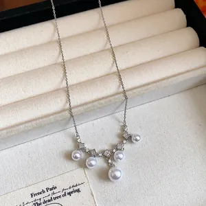 Detailaufnahme einer eleganten Silberkette mit Zirkonia und hängenden weißen Perlen