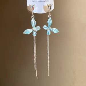 Dettaglio dei orecchini a farfalla in argento con smalto blu e strass brillanti