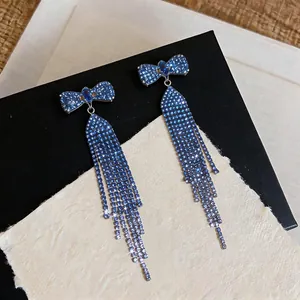 Detail of blue rhinestone bow earrings with elegant long shimmering tassels