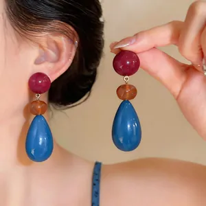 Vibrant resin teardrop earrings with multi-color bead design in close-up detail