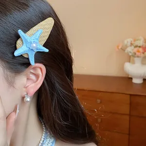 Close-up of a bohemian blue starfish pearl hair clip worn on long dark hair, beach style